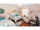This bedroom has wood floors, ceiling fan, daybed, desk, and is nicely decorated with coastal decor at 2225 Cypress Ct # 2C, Tavares, FL 32778