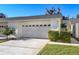 Attached two-car garage with carriage door, front lawn and walkway at 2225 Cypress Ct # 2C, Tavares, FL 32778