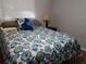 Inviting bedroom with a floral comforter, bedside lamp, and natural light from the window at 2416 Briarwood Ln, Eustis, FL 32726