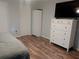 Bright bedroom features wood floor and ample storage with wardrobe and chest of drawers at 2416 Briarwood Ln, Eustis, FL 32726