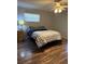 Cozy bedroom featuring wood-look floors, a ceiling fan, and natural light from the window at 2416 Briarwood Ln, Eustis, FL 32726