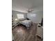 Bright bedroom with wood-look floors, a ceiling fan, and a comfortable bed at 2416 Briarwood Ln, Eustis, FL 32726