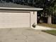 Attached two-car garage with updated door, exterior lighting, and meticulous landscaping at 2416 Briarwood Ln, Eustis, FL 32726