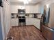 Stylish kitchen featuring stainless steel appliances, white cabinetry, and hardwood floors at 2416 Briarwood Ln, Eustis, FL 32726