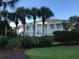 Elegant white clubhouse with stately columns, surrounded by lush landscaping and mature palm trees at 25527 Oak Aly, Leesburg, FL 34748
