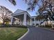 Elegant exterior of a white building featuring columns and a grand entrance; lush landscaping at 25527 Oak Aly, Leesburg, FL 34748