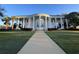 Exterior of building with impressive columns and well-manicured lawn; walkway leads to the entrance at 25527 Oak Aly, Leesburg, FL 34748