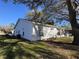 Side exterior of home featuring air conditioning unit, manicured lawn, and enclosed sunroom at 25527 Oak Aly, Leesburg, FL 34748