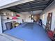 Well-lit garage with painted floor, storage shelves, and garage door, creating an organized and functional space at 25527 Oak Aly, Leesburg, FL 34748