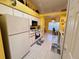 Bright kitchen featuring white cabinets, microwave, oven, refrigerator, and view of adjacent office at 25527 Oak Aly, Leesburg, FL 34748