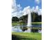 Picturesque pond with fountain and lily pads set against a blue sky with scattered clouds at 25527 Oak Aly, Leesburg, FL 34748