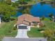 Stunning aerial view of home, meticulously landscaped yard, and a serene lake backdrop at 26636 Evert St, Leesburg, FL 34748