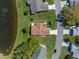 An aerial view shows the home with mature landscaping near the pond, trees, and a nearby street at 26636 Evert St, Leesburg, FL 34748