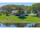 Lush backyard near the water featuring a small patio area, and a fire pit along the water line at 26636 Evert St, Leesburg, FL 34748