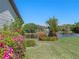 Beautiful backyard featuring manicured lawn, colorful landscaping and peaceful water view at 26636 Evert St, Leesburg, FL 34748