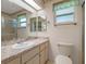 Bright bathroom featuring a large mirror, tiled shower, and marble counter at 26636 Evert St, Leesburg, FL 34748