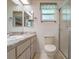Bright bathroom with light countertop, shower, and toilet; natural light from skylight at 26636 Evert St, Leesburg, FL 34748