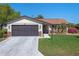 Charming single-story home featuring a two-car garage, stone accents, and a well-manicured lawn with beautiful landscaping at 26636 Evert St, Leesburg, FL 34748