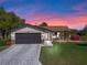 Charming single-story home featuring a two-car garage, stone accents, and a well-manicured lawn with beautiful landscaping at 26636 Evert St, Leesburg, FL 34748