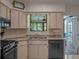 Traditional kitchen showcasing cabinets, counters, black appliances and view to patio at 26636 Evert St, Leesburg, FL 34748