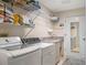 Well-equipped laundry room with washer, dryer, shelving, and sink for convenience at 26636 Evert St, Leesburg, FL 34748