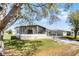Charming single-story home featuring a carport, screened-in porch, and well-maintained landscaping at 27 Florence Blvd, Debary, FL 32713