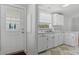 Galley kitchen with white cabinets and appliances, connected to a doorway at 27 Florence Blvd, Debary, FL 32713