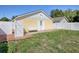 Backyard featuring a side door, a wood deck with bench, and partial privacy fence at 2741 S Brown Ave, Orlando, FL 32806