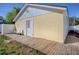 Exterior angle of backyard featuring the side door and a wood deck with bench at 2741 S Brown Ave, Orlando, FL 32806