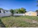 A sunny fenced backyard view with the side of the house and some trees at 2741 S Brown Ave, Orlando, FL 32806