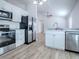 Modern kitchen featuring stainless steel appliances, white cabinetry, and wood-look flooring at 2741 S Brown Ave, Orlando, FL 32806