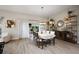 Elegant dining room with a modern chandelier, seating for six, and access to the living area at 2947 Rain Lily Loop, The Villages, FL 32163