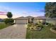 Beautiful single-story home featuring a well-manicured lawn, lush landscaping and a paver driveway at 2947 Rain Lily Loop, The Villages, FL 32163