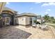 Charming home featuring a decorative paved patio, an arched entryway and manicured landscaping at 2947 Rain Lily Loop, The Villages, FL 32163