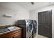 Modern laundry room with granite sink, stainless steel washer/dryer, and lots of storage space at 2947 Rain Lily Loop, The Villages, FL 32163