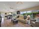 Spacious living room with vaulted ceilings, tile floors, and lots of natural light from large windows at 2947 Rain Lily Loop, The Villages, FL 32163