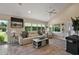 Bright living room with vaulted ceilings, tile floors, and lots of natural light from large windows at 2947 Rain Lily Loop, The Villages, FL 32163