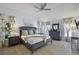 Comfortable main bedroom featuring a ceiling fan, hardwood floors, and bright natural light from multiple windows at 2947 Rain Lily Loop, The Villages, FL 32163