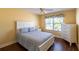 Cozy bedroom with a window, white furniture, and wood floors at 314 Olanta Dr, The Villages, FL 32162