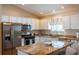 Modern kitchen with stainless steel appliances, granite countertops, a kitchen island, and ample cabinet space at 314 Olanta Dr, The Villages, FL 32162