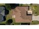 Birds eye view of a well-maintained roof surrounded by a green lawn, landscaping, and mature trees on a sunny day at 314 Olanta Dr, The Villages, FL 32162