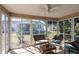 Enjoy the sunroom with wicker furniture overlooking the landscaped backyard through glass windows at 314 Olanta Dr, The Villages, FL 32162