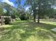 Large backyard featuring mature trees, a well-maintained lawn, and a wooden fence for added privacy at 3309 Ne 16Th Ave, Ocala, FL 34479