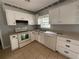 Functional kitchen featuring white cabinets, appliances, and neutral countertops at 3309 Ne 16Th Ave, Ocala, FL 34479