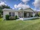 View of the screened-in lanai in the rear of the house, set on a well-maintained lawn at 3337 Ashbrook Pl, The Villages, FL 32162