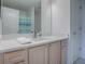 Well-lit bathroom with quartz counters and natural wood cabinets at 3337 Ashbrook Pl, The Villages, FL 32162