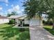 Beautiful front exterior with a lush lawn, mature trees, and a well-maintained landscape at 3337 Ashbrook Pl, The Villages, FL 32162