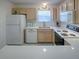 Efficient kitchen featuring wood cabinets, white countertops, and appliances with a bright window at 3337 Ashbrook Pl, The Villages, FL 32162