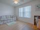 Bright living room featuring a comfortable sofa, laminate flooring, and large window with natural light at 3337 Ashbrook Pl, The Villages, FL 32162