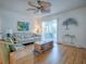 Bright living room with a ceiling fan and hardwood floors, leading to an outdoor patio at 3337 Ashbrook Pl, The Villages, FL 32162